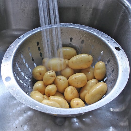 Rinsing potatoes under running water in a calendar. 