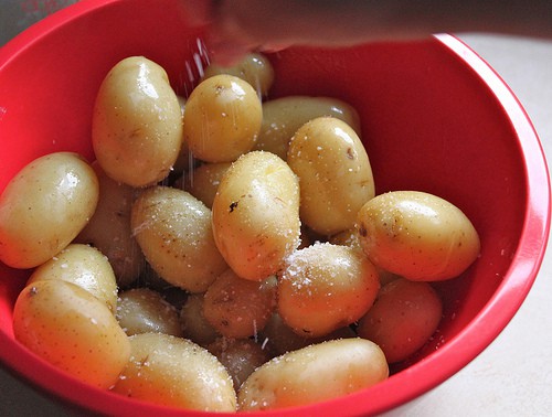 Steamed Potatoes with kosher salt in a red bowl.