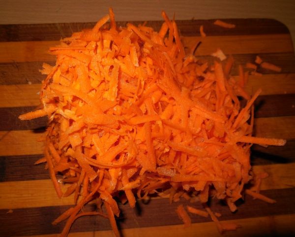 Тёртая морковь на разделочной деревянной доске
