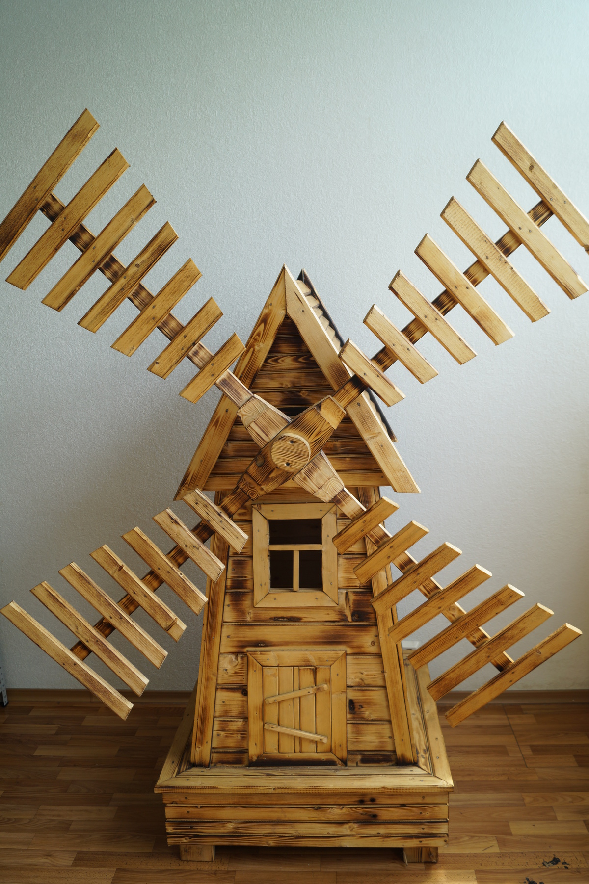 Небольшая декоративная мельница из дерева для украшения территории дома