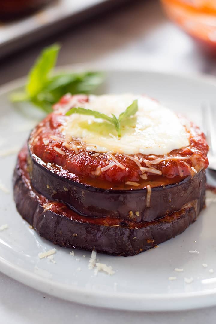 A close up image of a single serving of Baked Eggplant Parmesan made with roasted eggplant, homemade tomato sauce, mozzarella and grated parmesan.