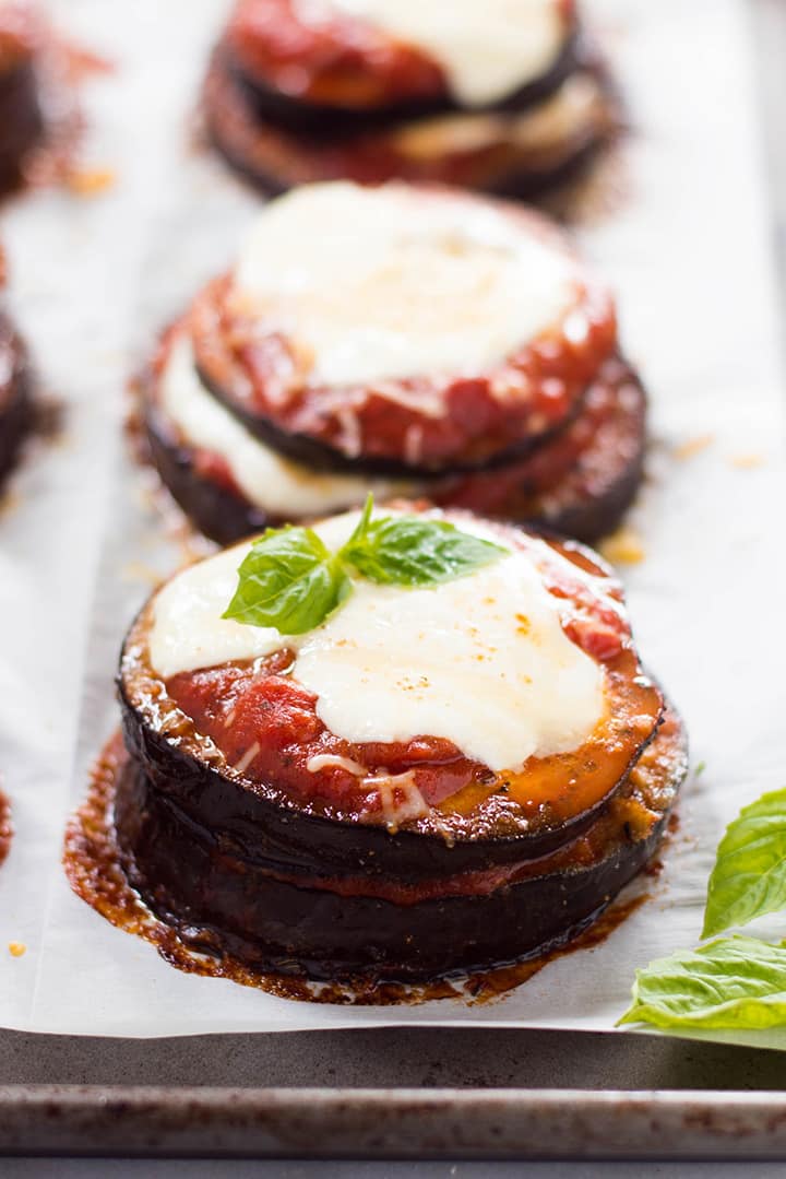 A side image of Baked Eggplant Parmesan made with roasted eggplant, homemade tomato sauce, mozzarella and grated parmesan.