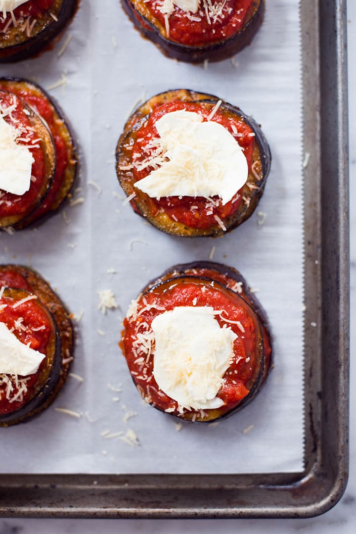 A close up image of Baked Eggplant Parmesan, made with roasted eggplant, homemade tomato sauce, mozzarella and grated parmesan, before placing it in the oven.