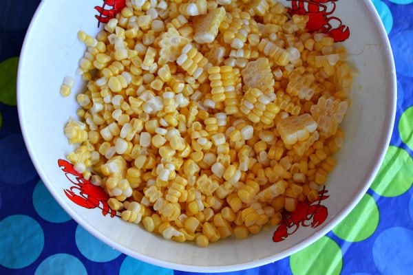 Fresh Corn, Zucchini and Tomato Salad recipe from RecipeGirl.com #corn #zucchini #tomato #summer #salad #recipe #RecipeGirl fresh corn in a white bowl with lobster print, set on a blue and green polka dot tablecloth